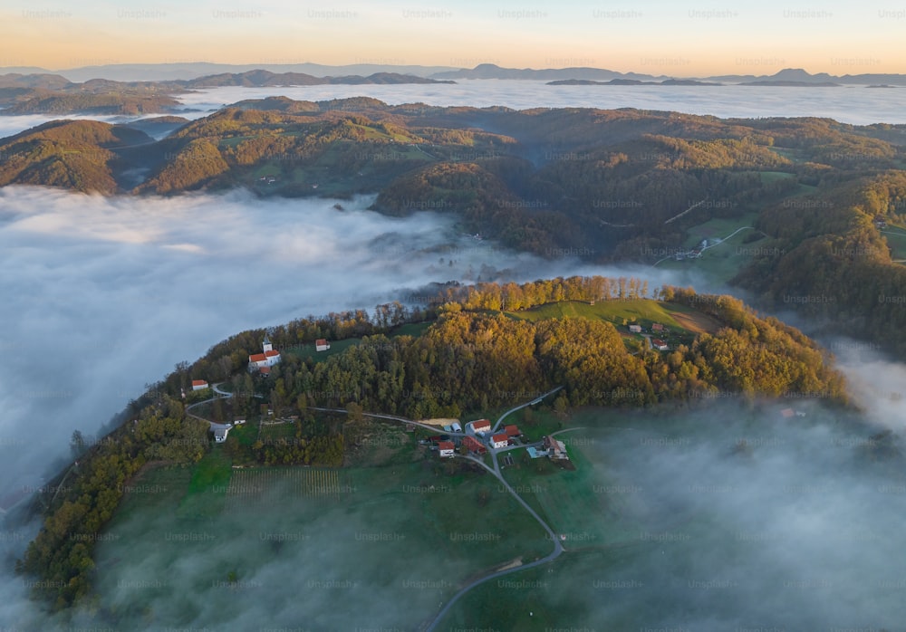 uma vista aérea de uma pequena aldeia cercada por nevoeiro