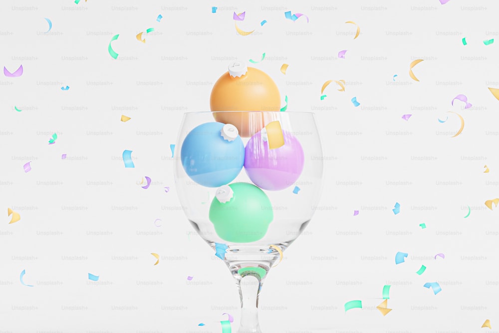 ein Weinglas gefüllt mit bunten Luftballons und Konfetti