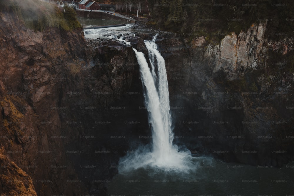 a waterfall with a bridge in the background