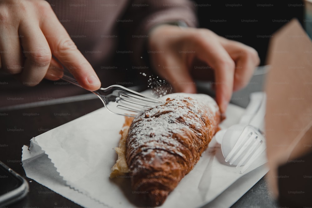 a person eating a pastry with a fork and knife