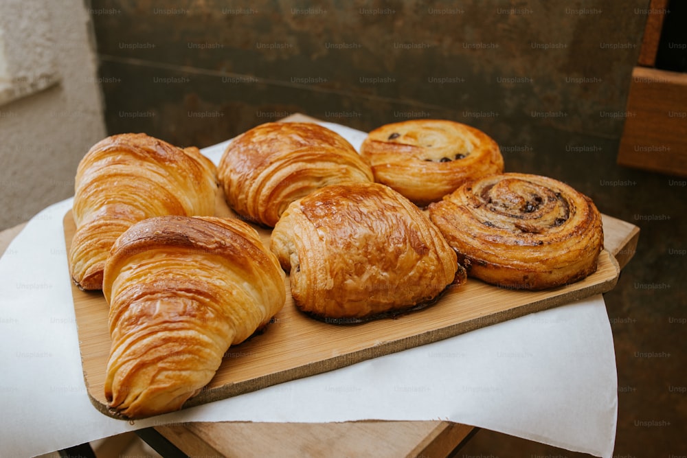 a wooden cutting board topped with lots of pastries
