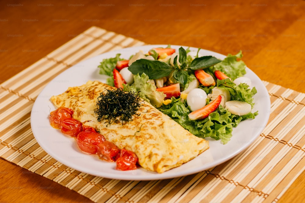 um prato branco coberto com uma omelete ao lado de uma salada