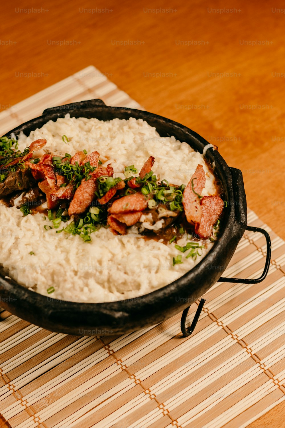 une poêle remplie de riz et de viande sur une natte