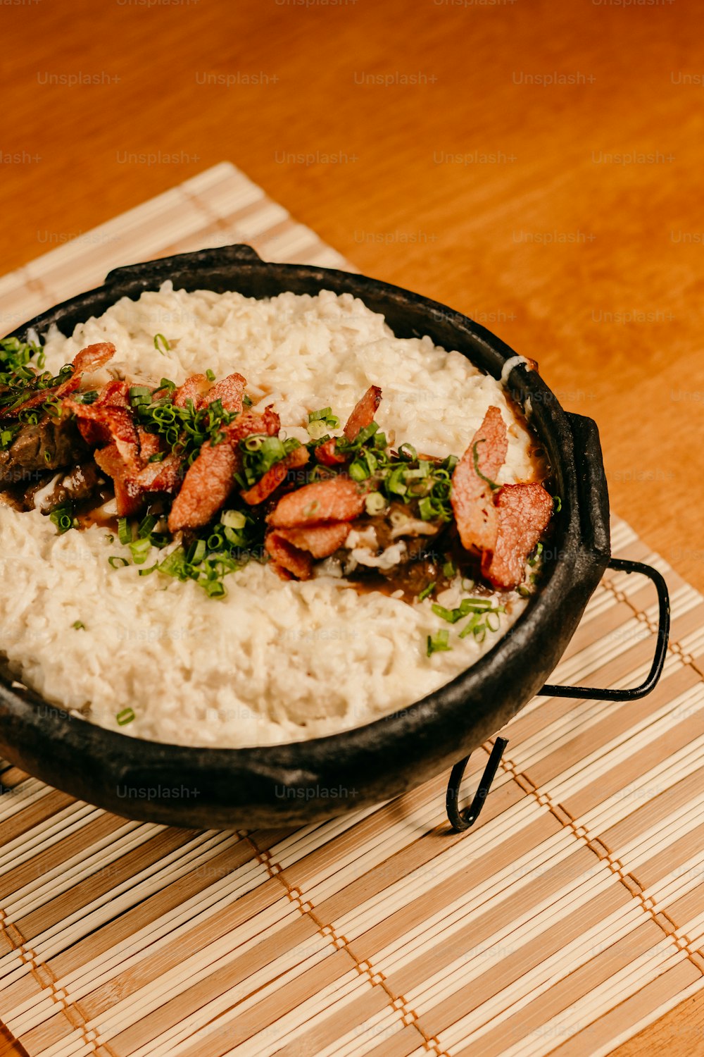 a skillet filled with rice and meat on a mat