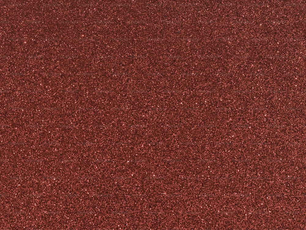 Gros plan d’une surface texturée pailletée rouge