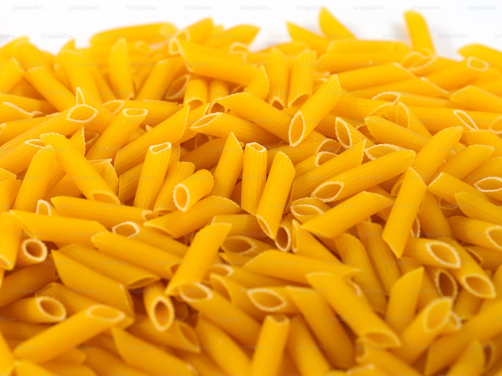 a pile of yellow pasta on a white surface