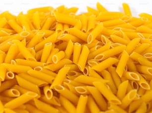a pile of yellow pasta on a white surface