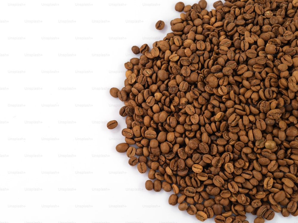 uma pilha de grãos de café em uma superfície branca