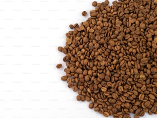 Una pila de granos de café sobre una superficie blanca