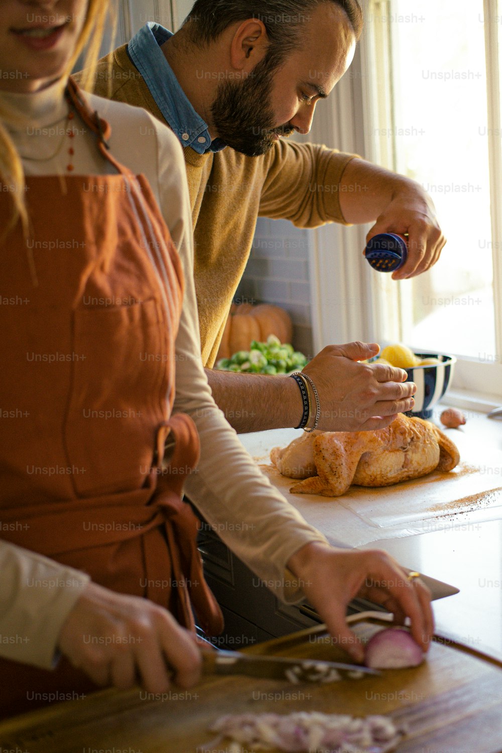 a man and a woman cutting onions on a cutting board