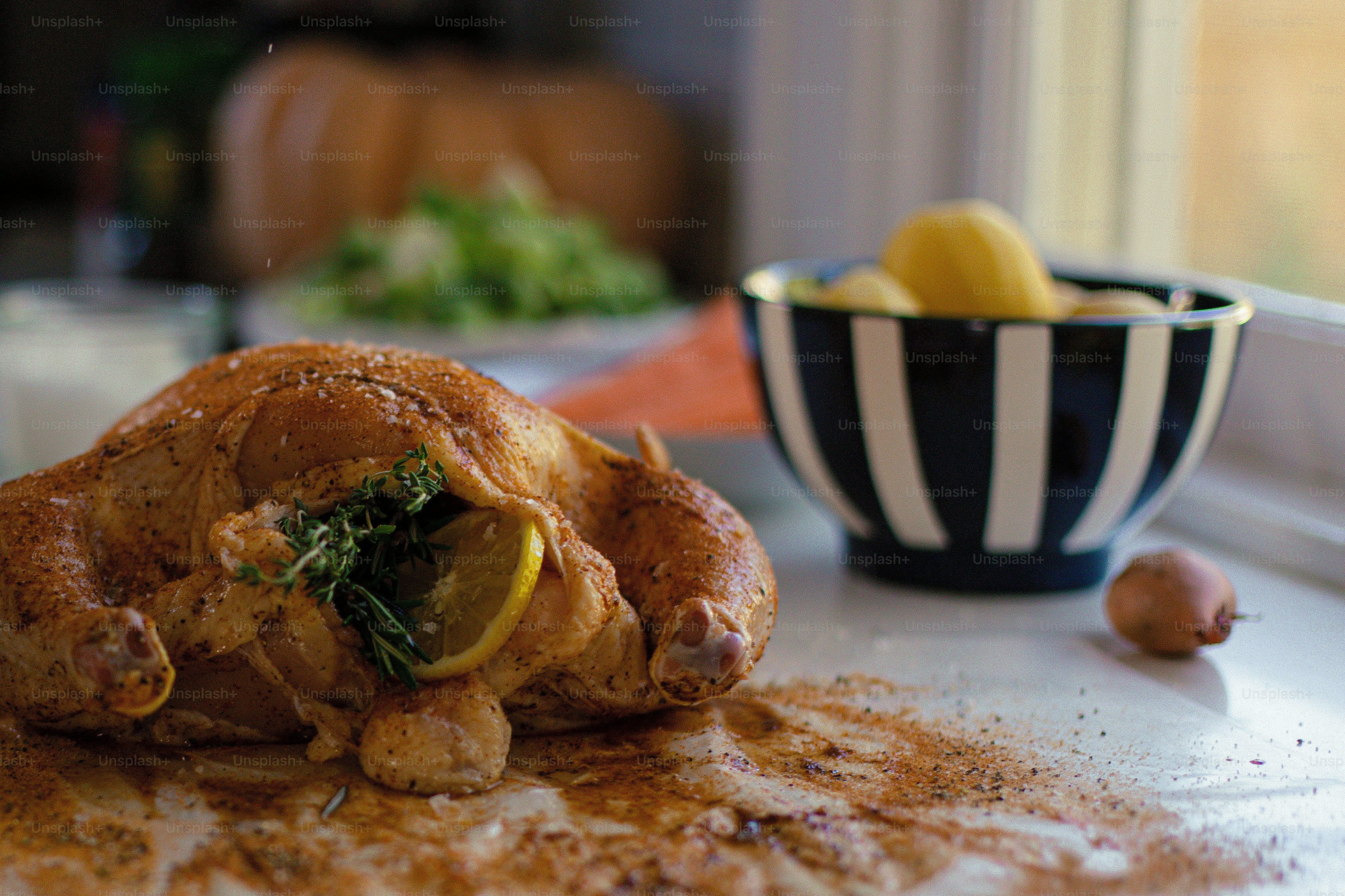 a whole chicken is on the counter next to a bowl of lemons