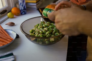 a bowl of carrots and brussel sprouts on a table