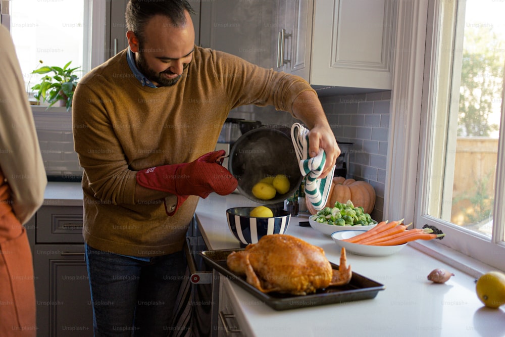 a man in a kitchen washing a turkey