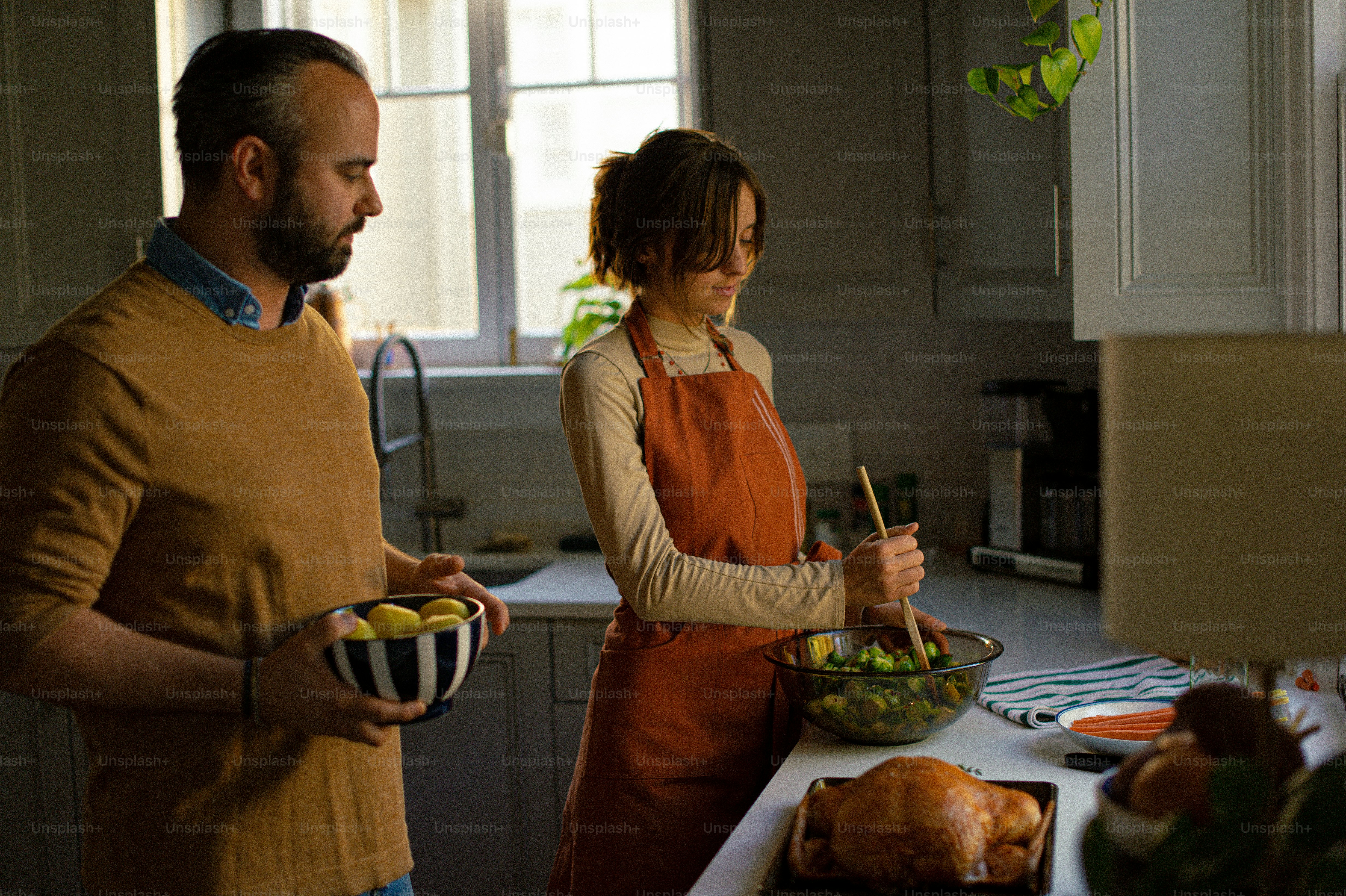a man and a woman preparing food in a kitchen