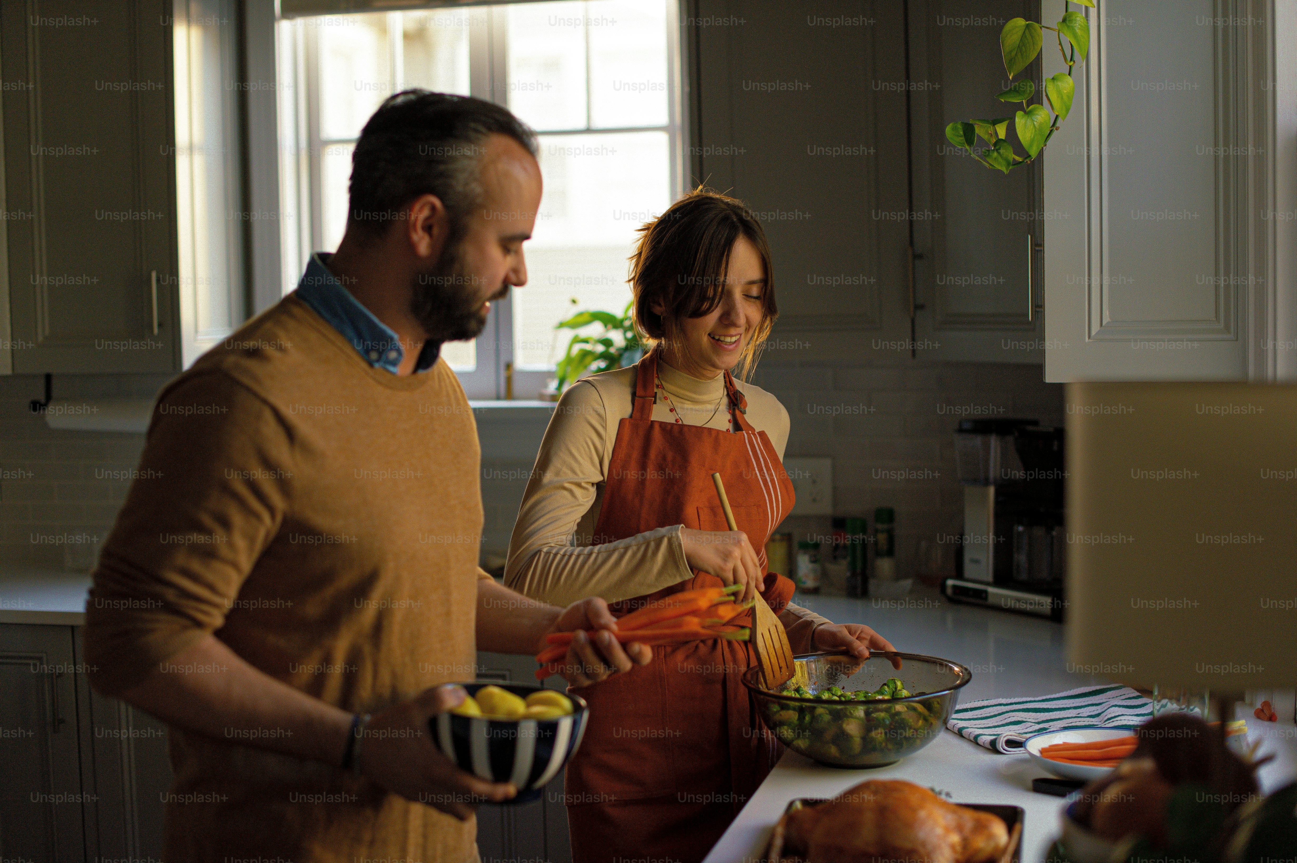a man and a woman preparing food in a kitchen