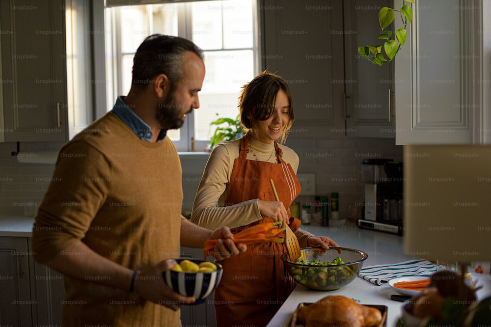 a man and a woman preparing food in a kitchen