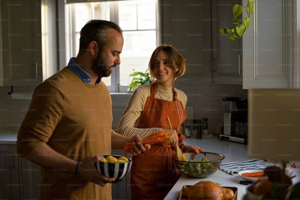 Un hombre y una mujer preparando comida en una cocina