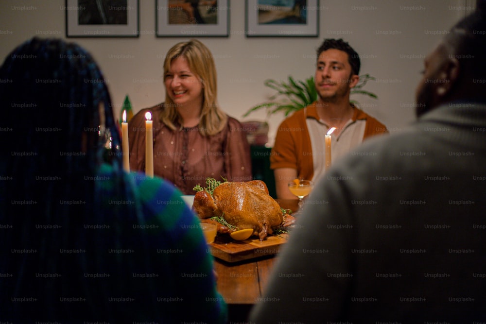 a group of people sitting around a table with a turkey on it