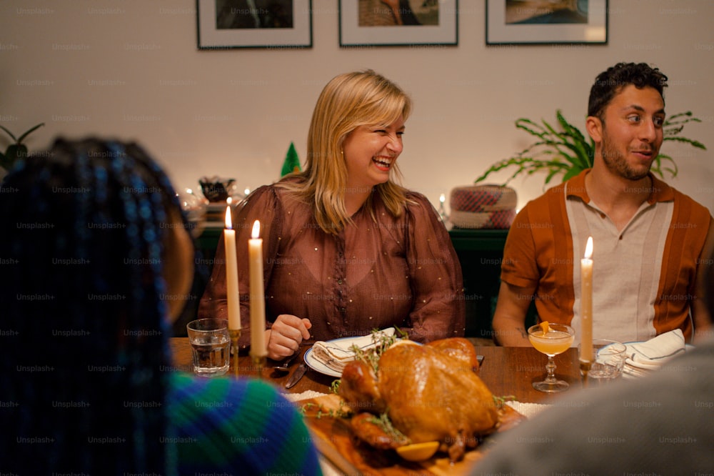 a group of people sitting around a table with a turkey