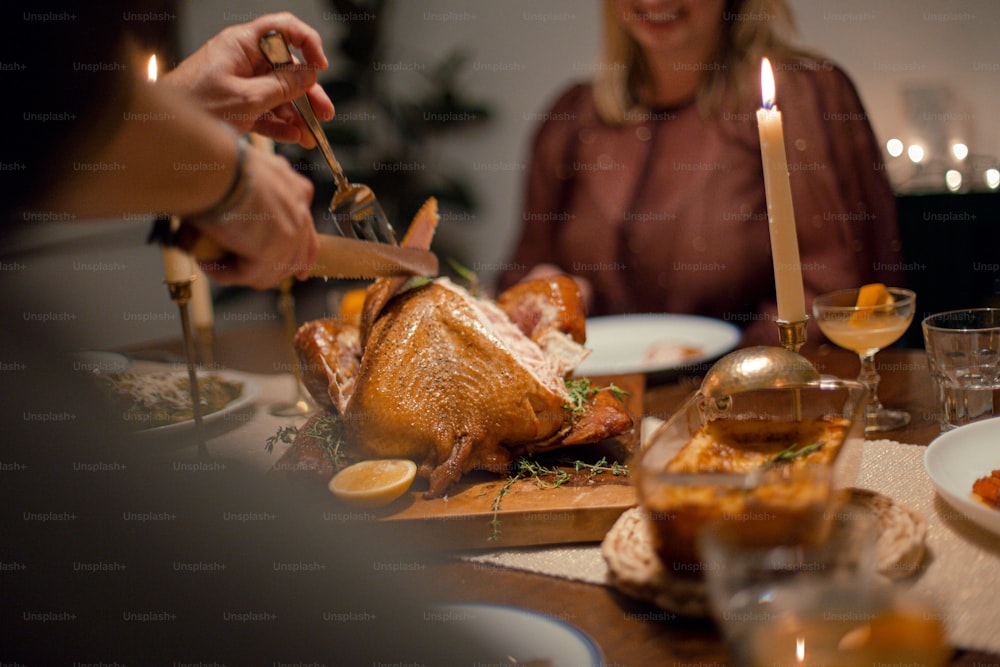 a woman is cutting a turkey on a table