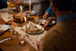 a group of people sitting around a table with plates of food