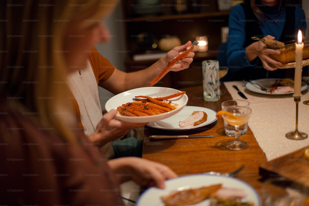 a group of people sitting around a table with plates of food