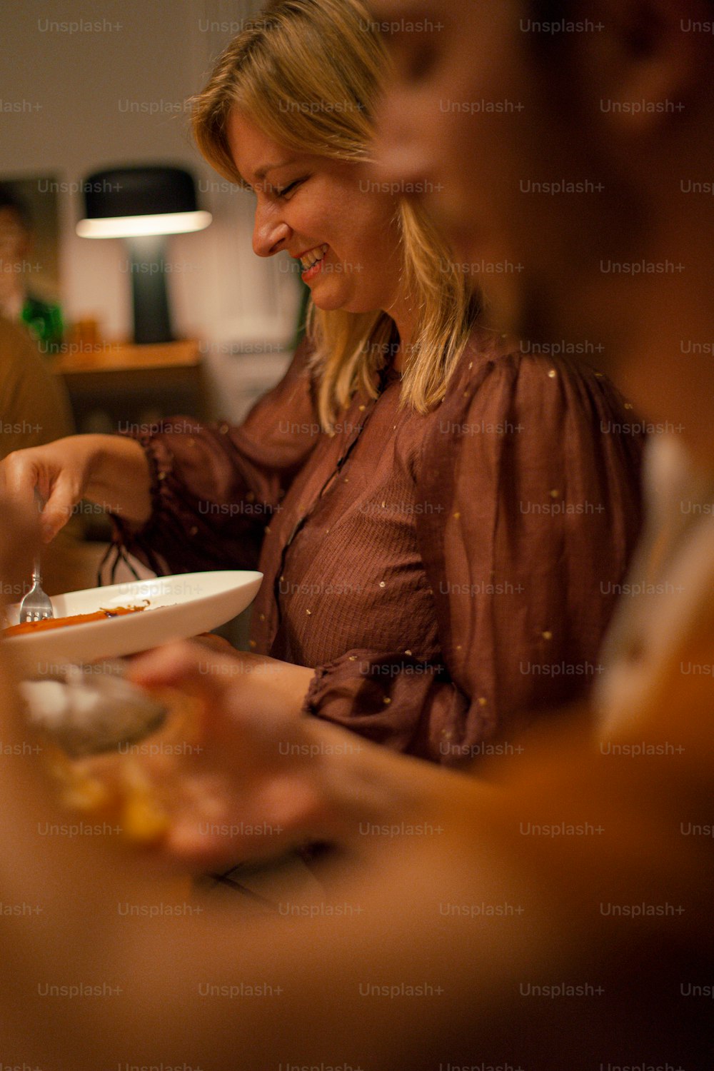 Une femme assise à une table avec une assiette de nourriture