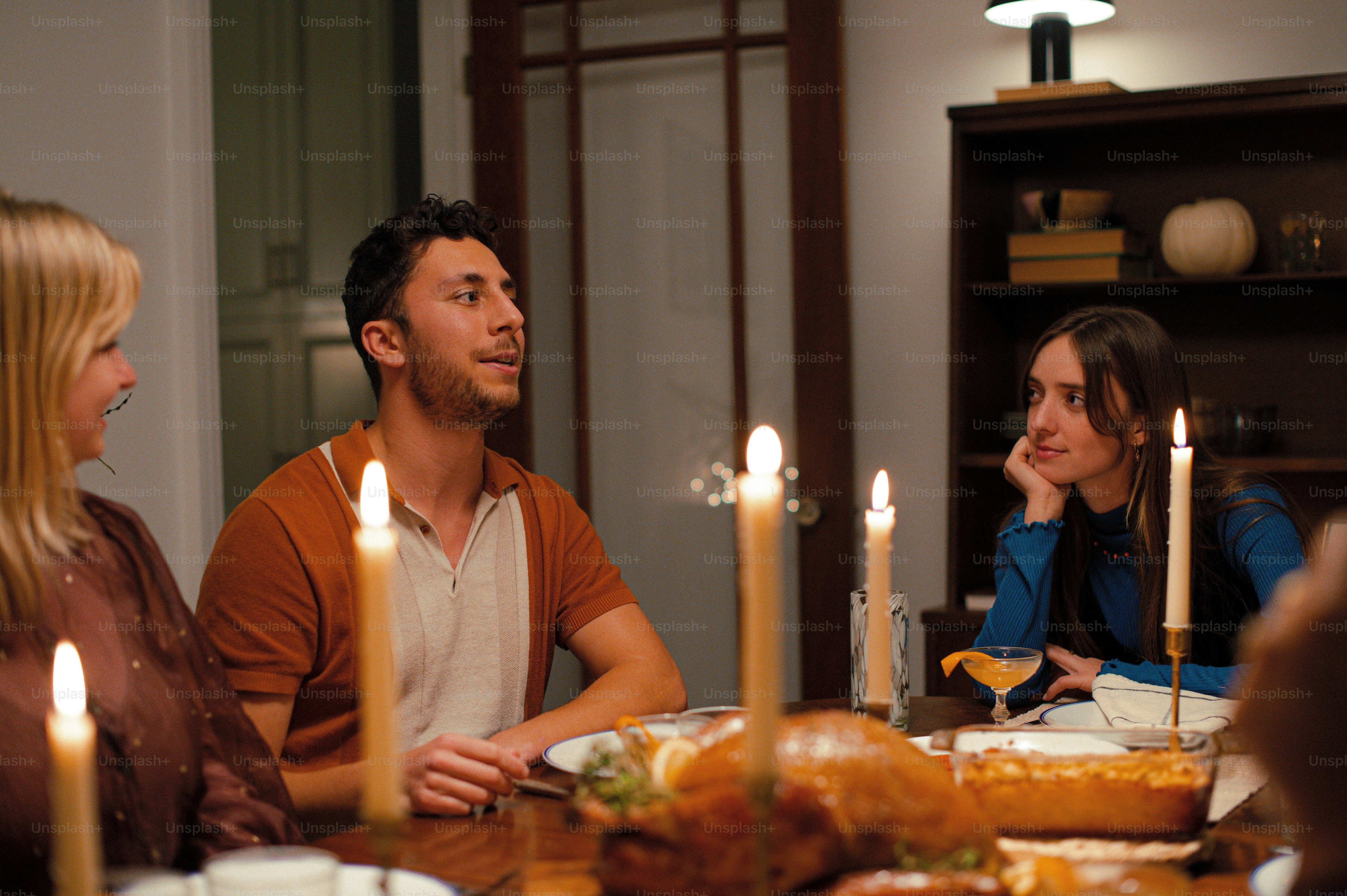 A group of people sitting around a dinner table photo – Food Image on