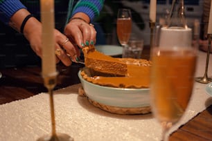 a person cutting a piece of cake with a knife