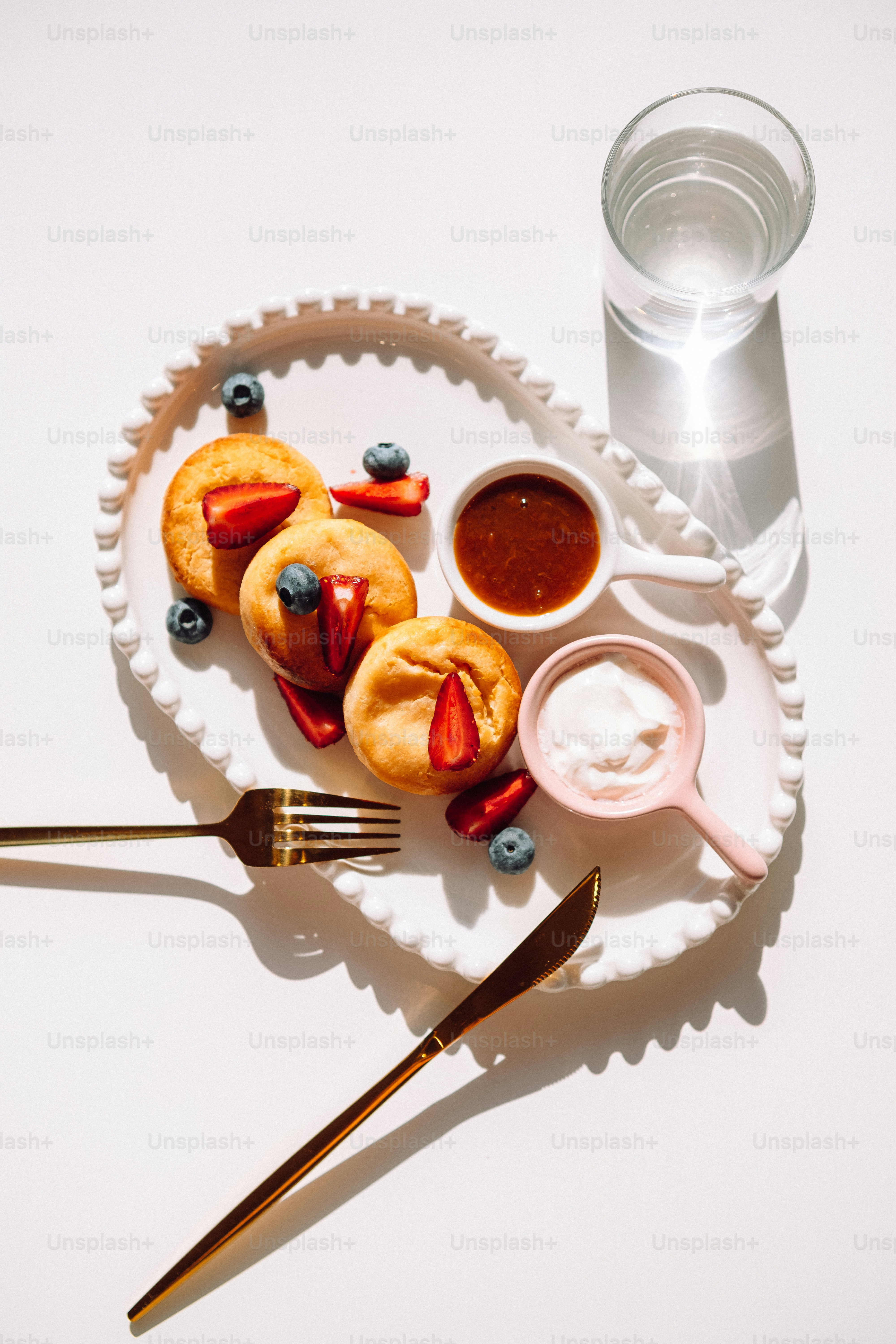 a white plate topped with pastries next to a glass of water