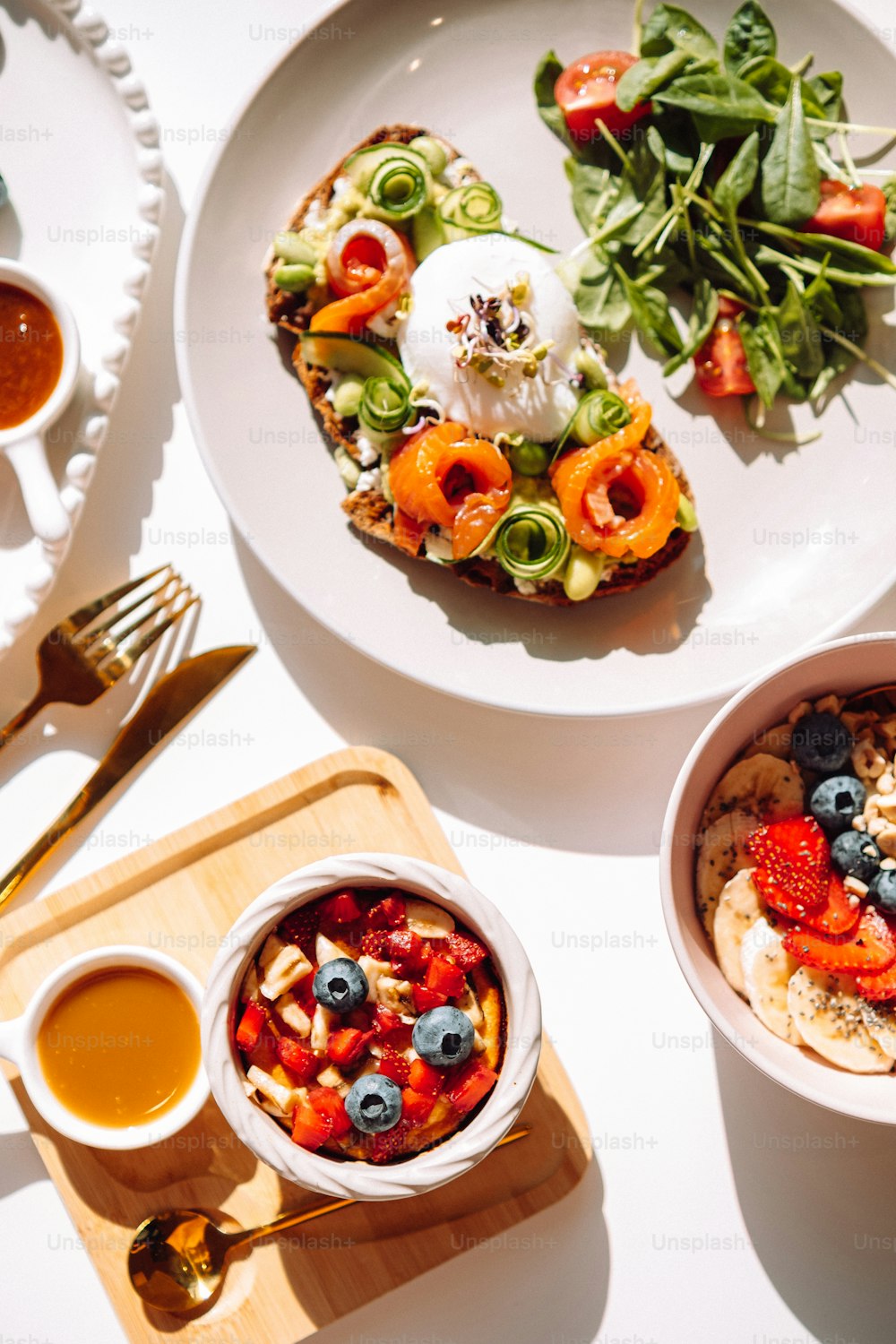 a white plate topped with food next to a bowl of salad