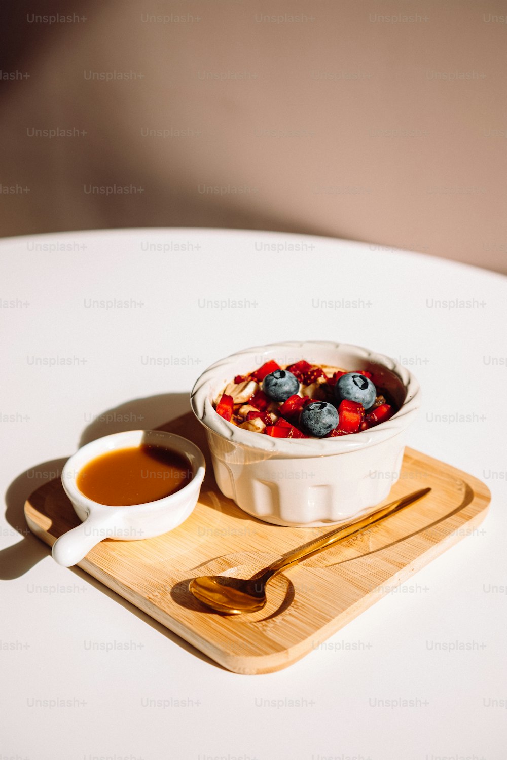 a bowl of fruit and a spoon on a table