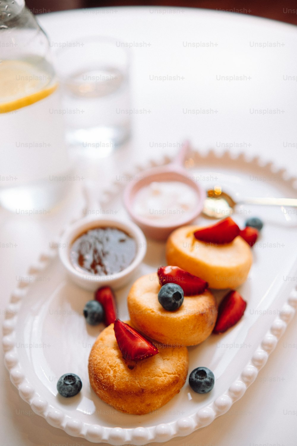 a white plate topped with pastries covered in fruit