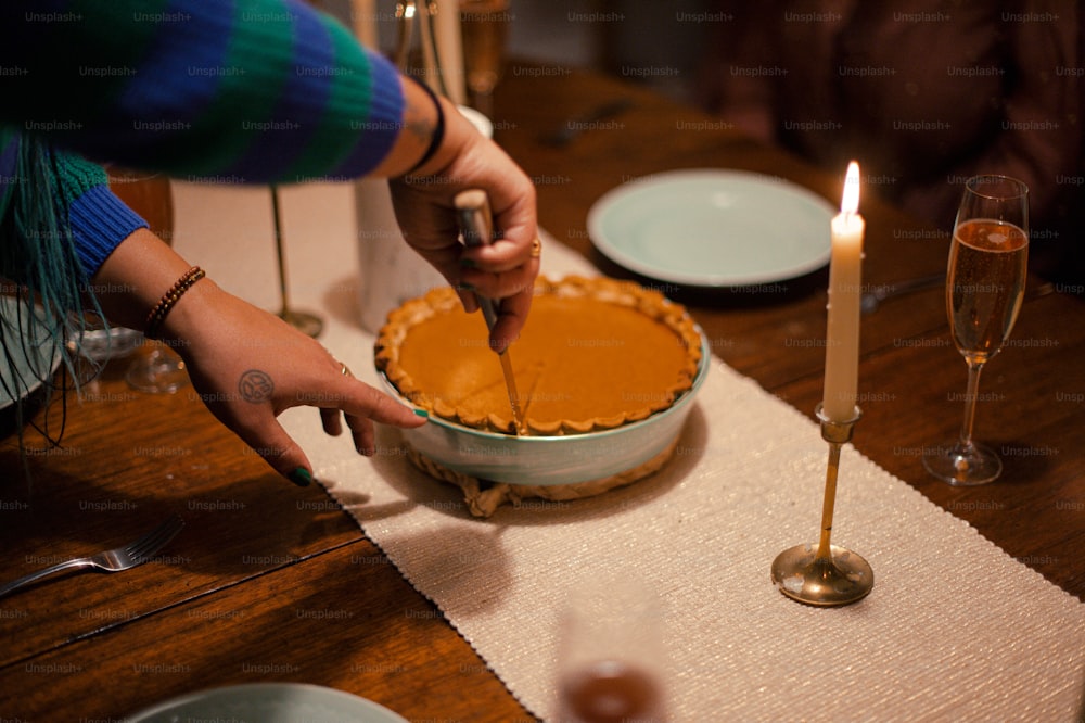 a person cutting a pie on a table