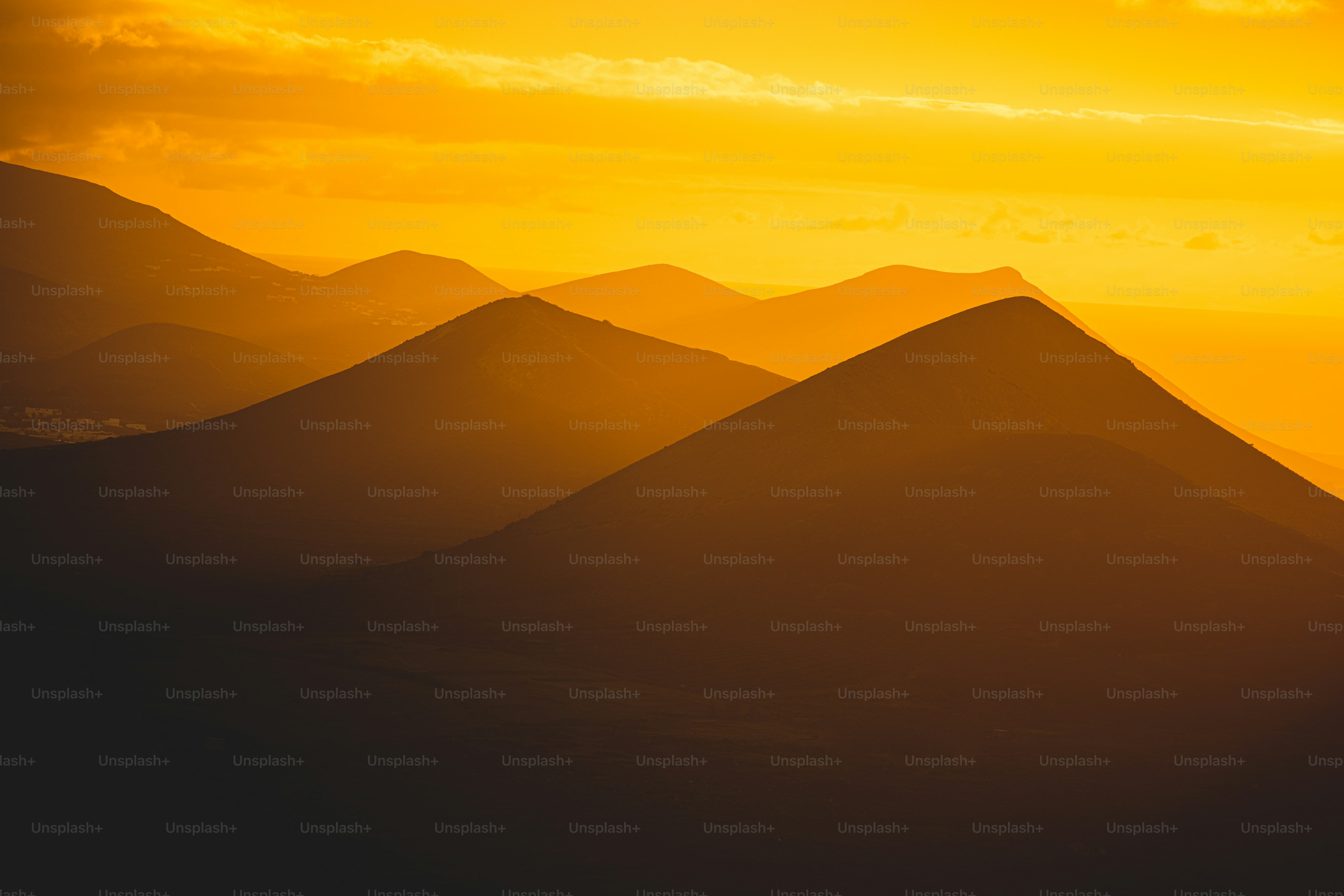 the sun is setting over a mountain range