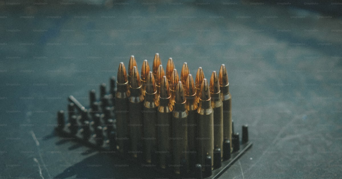 A bunch of bullet shells sitting on top of a table photo – Kyiv Image ...