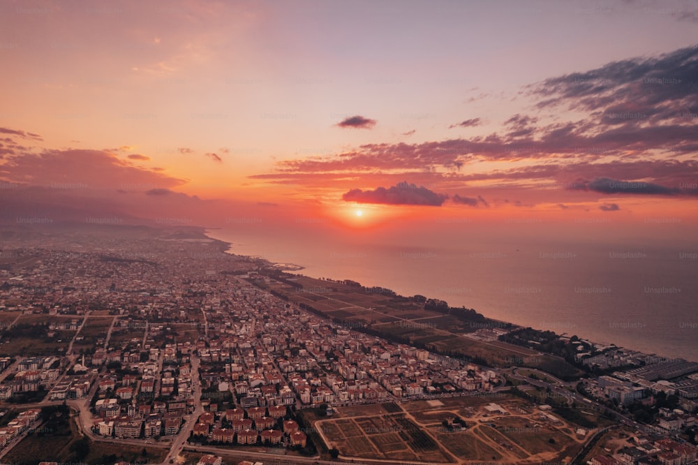 an aerial view of a city with a sunset in the background