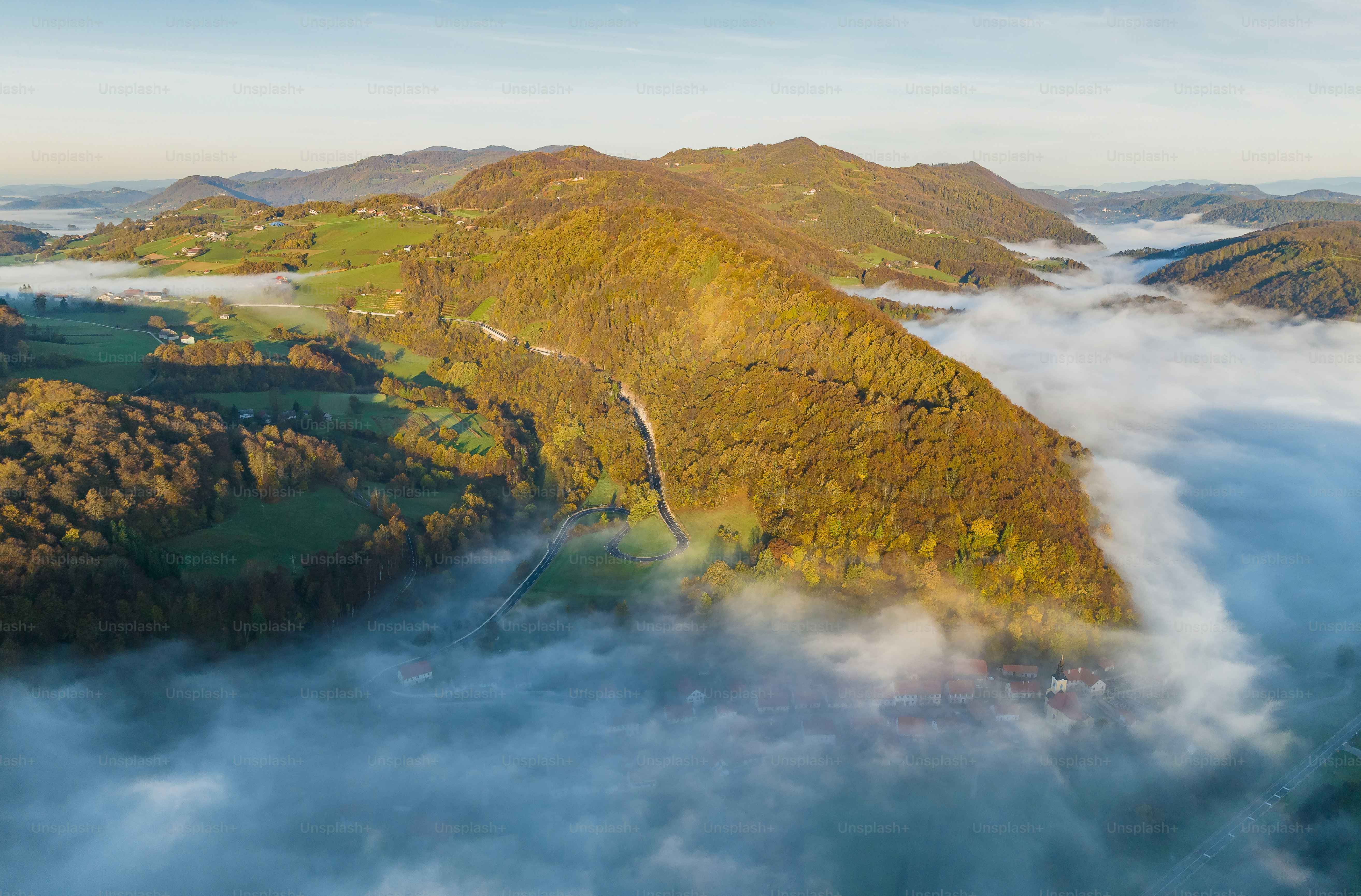 An aerial view of a mountain range with low lying clouds photo – Image ...