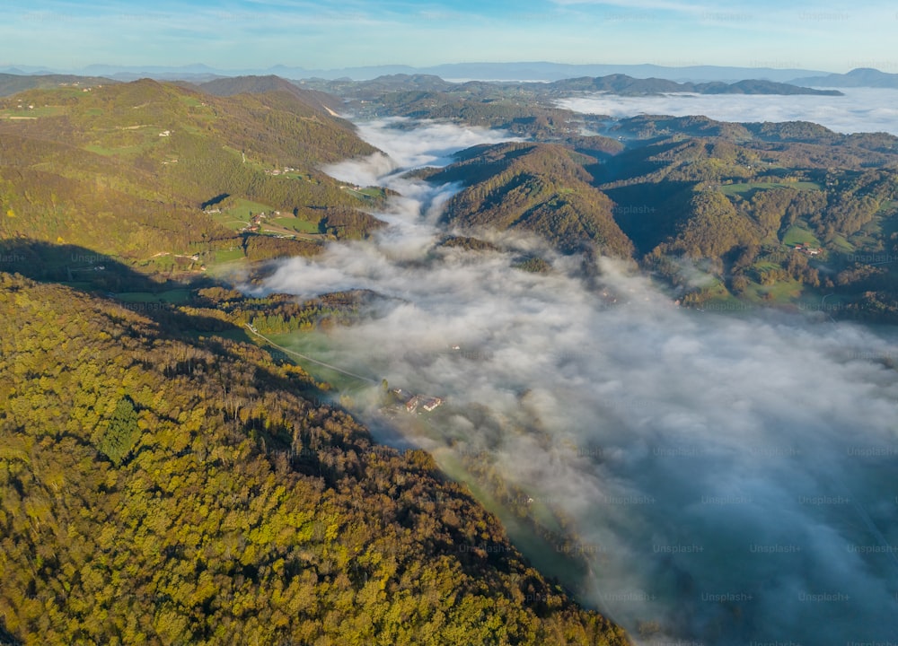an aerial view of a mountain range covered in clouds
