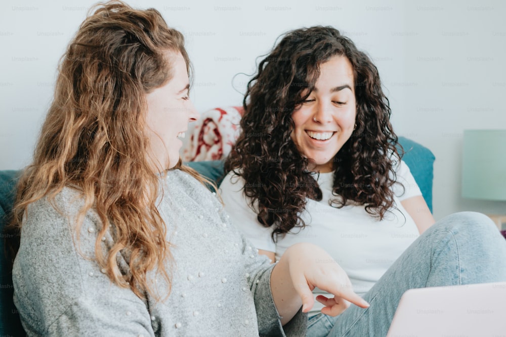 two women sitting on a couch talking to each other