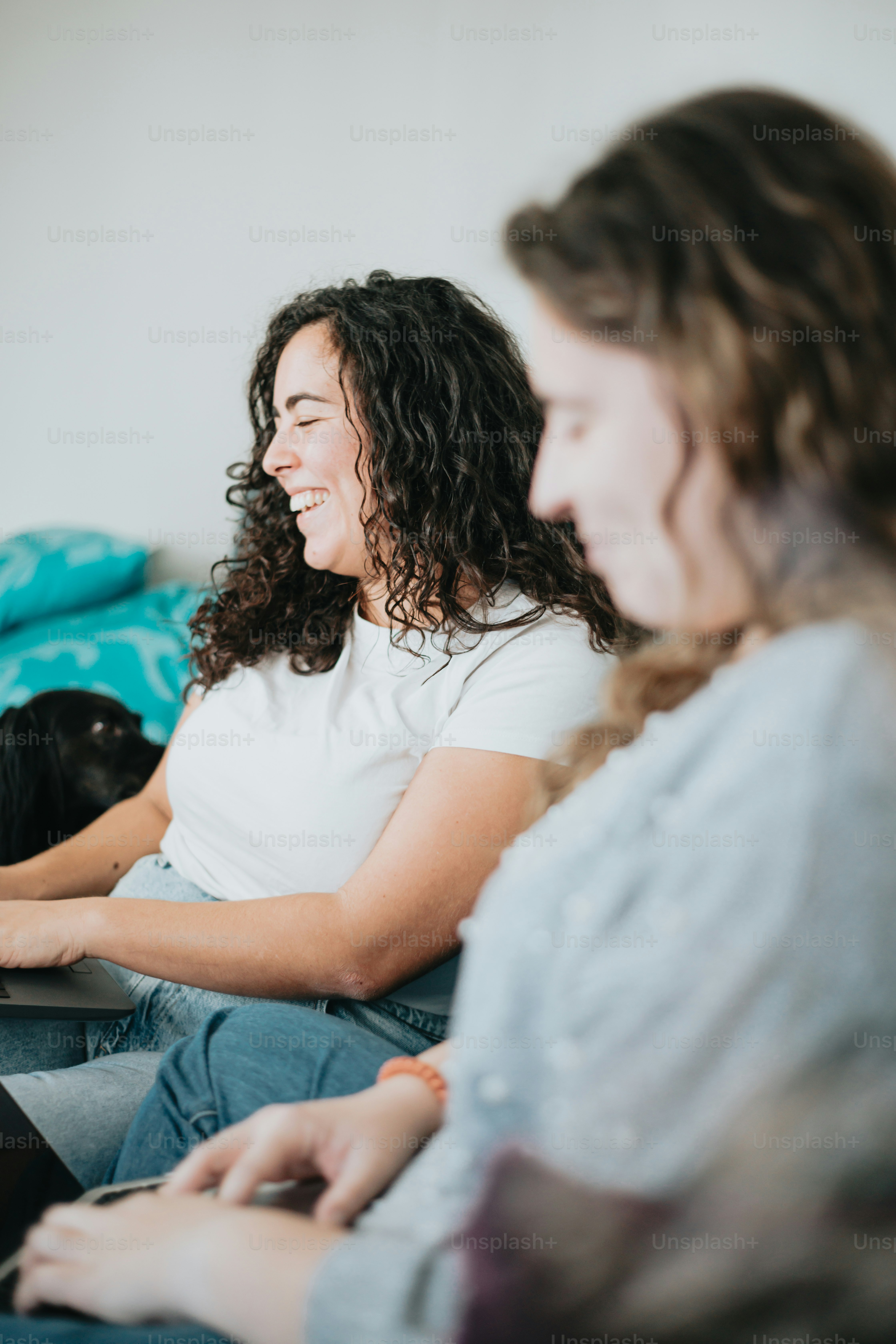 a couple of women sitting on top of a couch