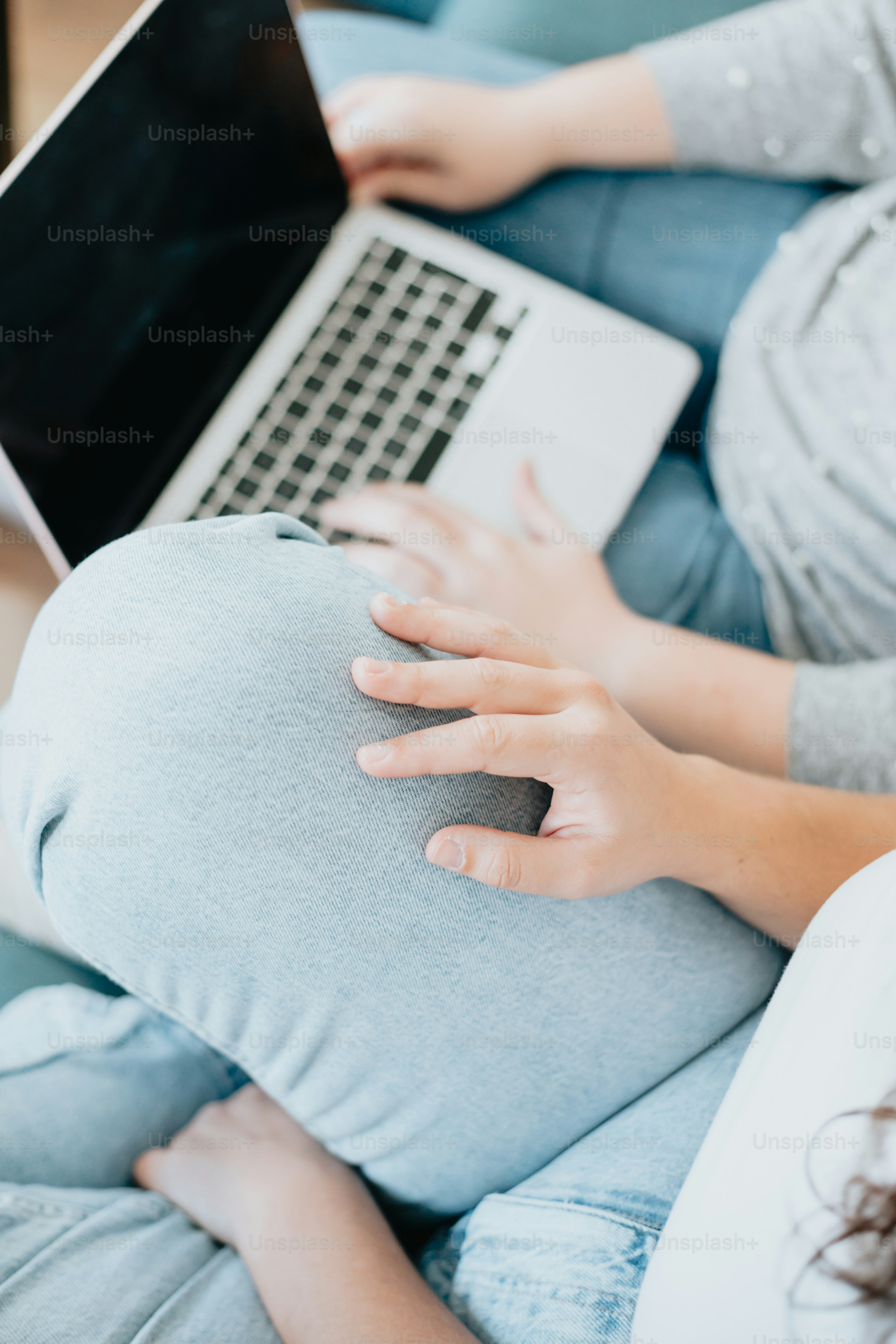 a pregnant woman using a laptop on her stomach