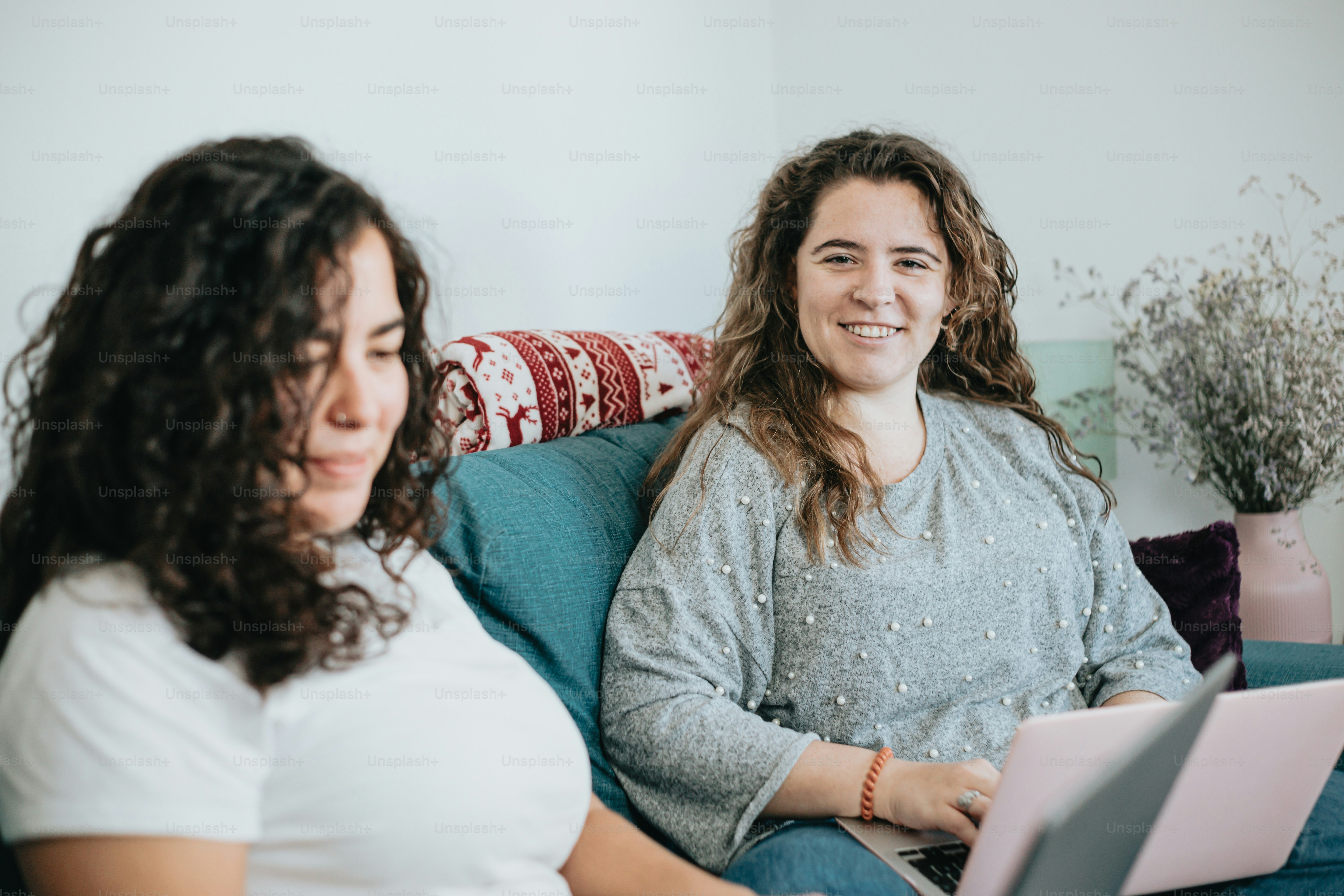 a couple of women sitting on top of a couch