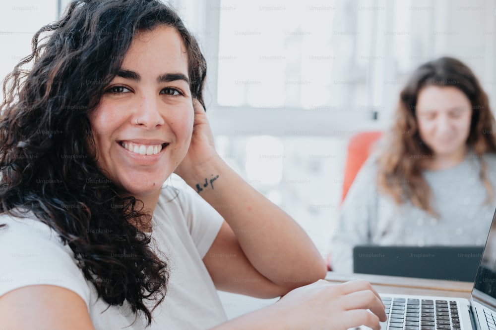 a woman sitting in front of a laptop computer