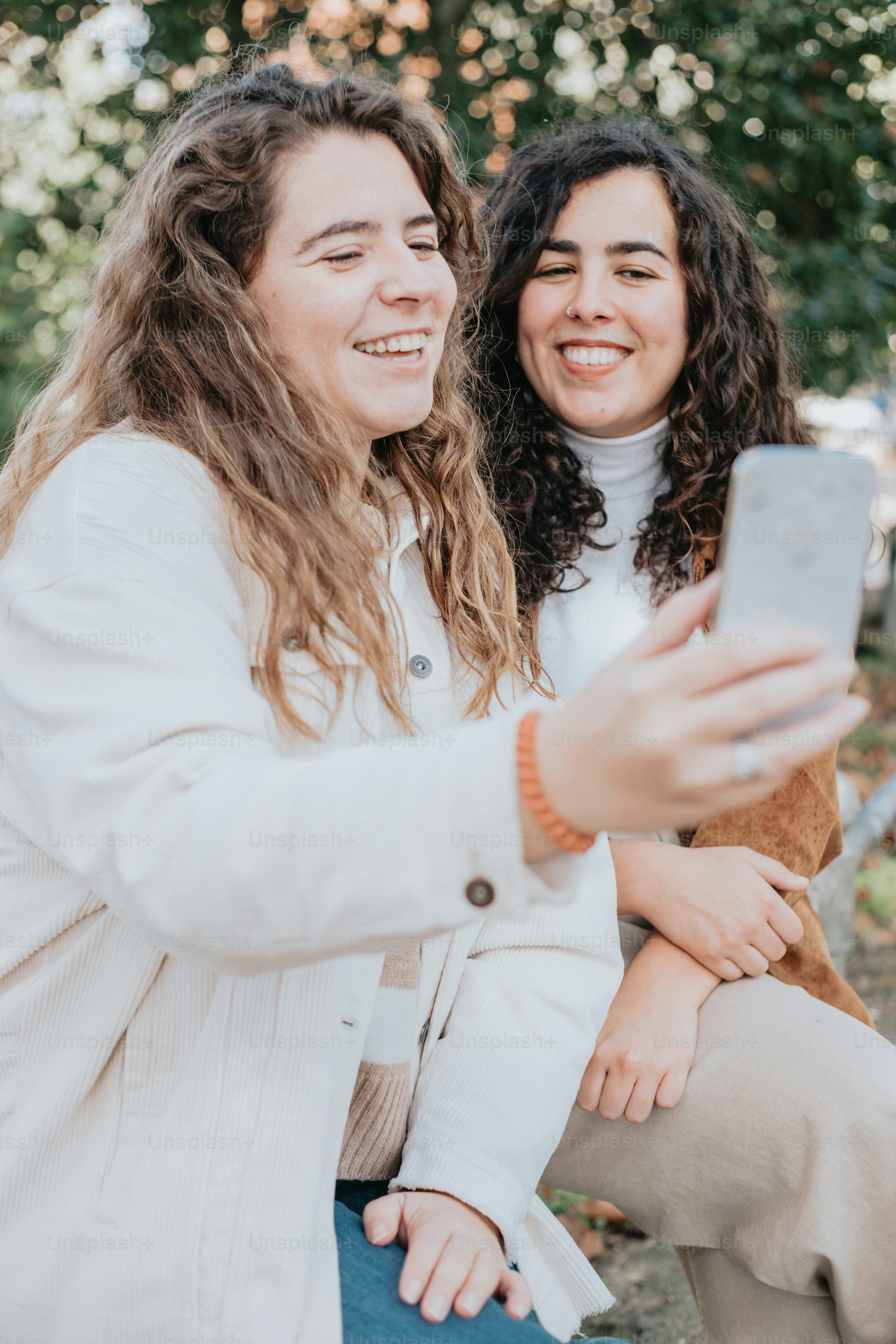 duas mulheres tirando uma selfie com um celular
