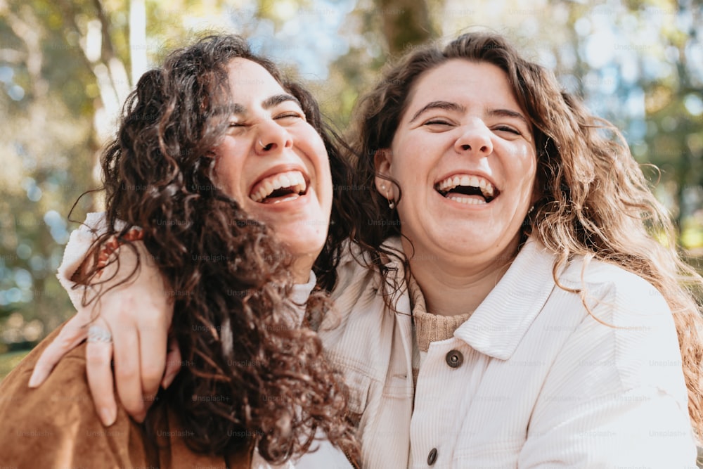 two women are smiling and hugging each other