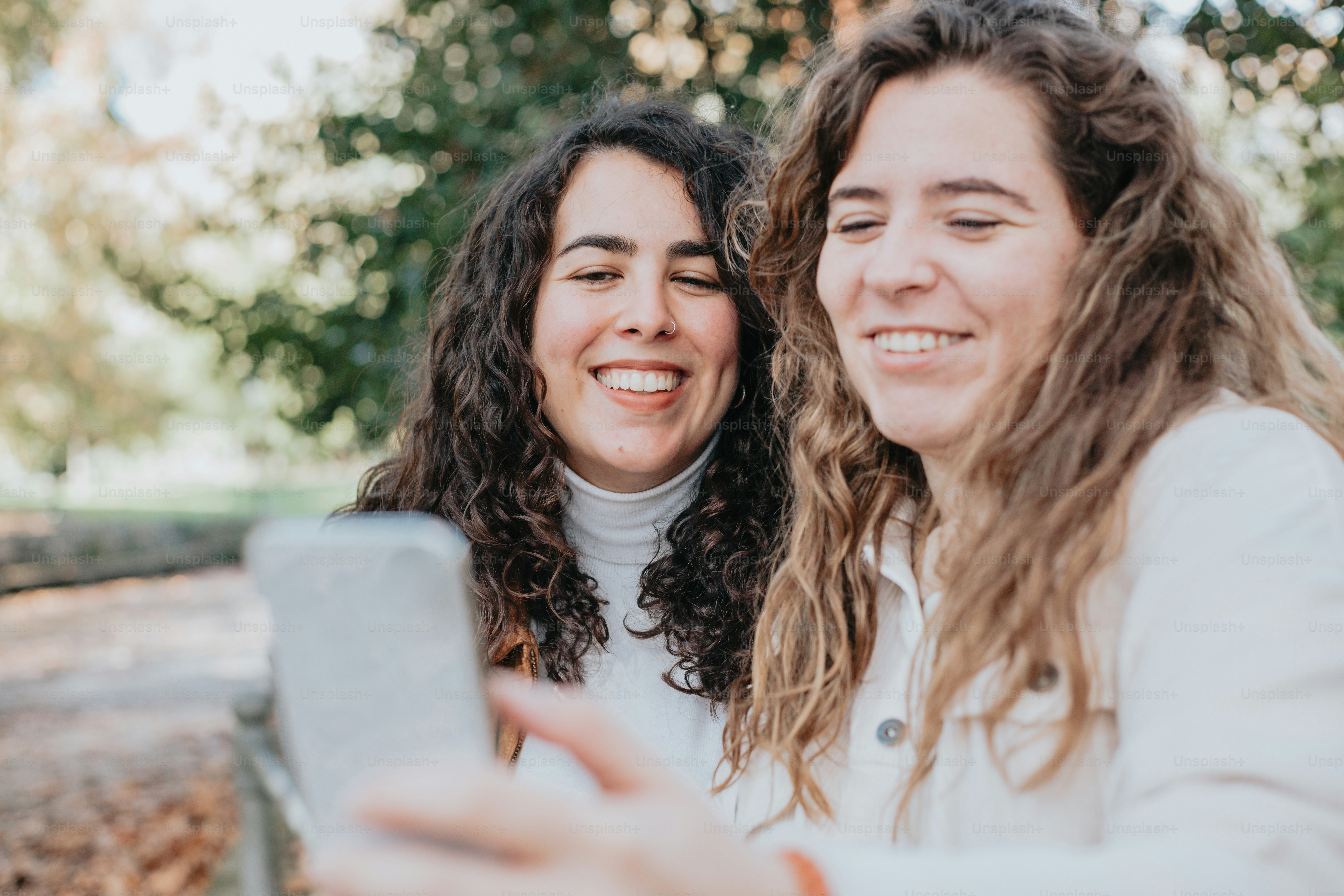 two women taking a picture with a cell phone