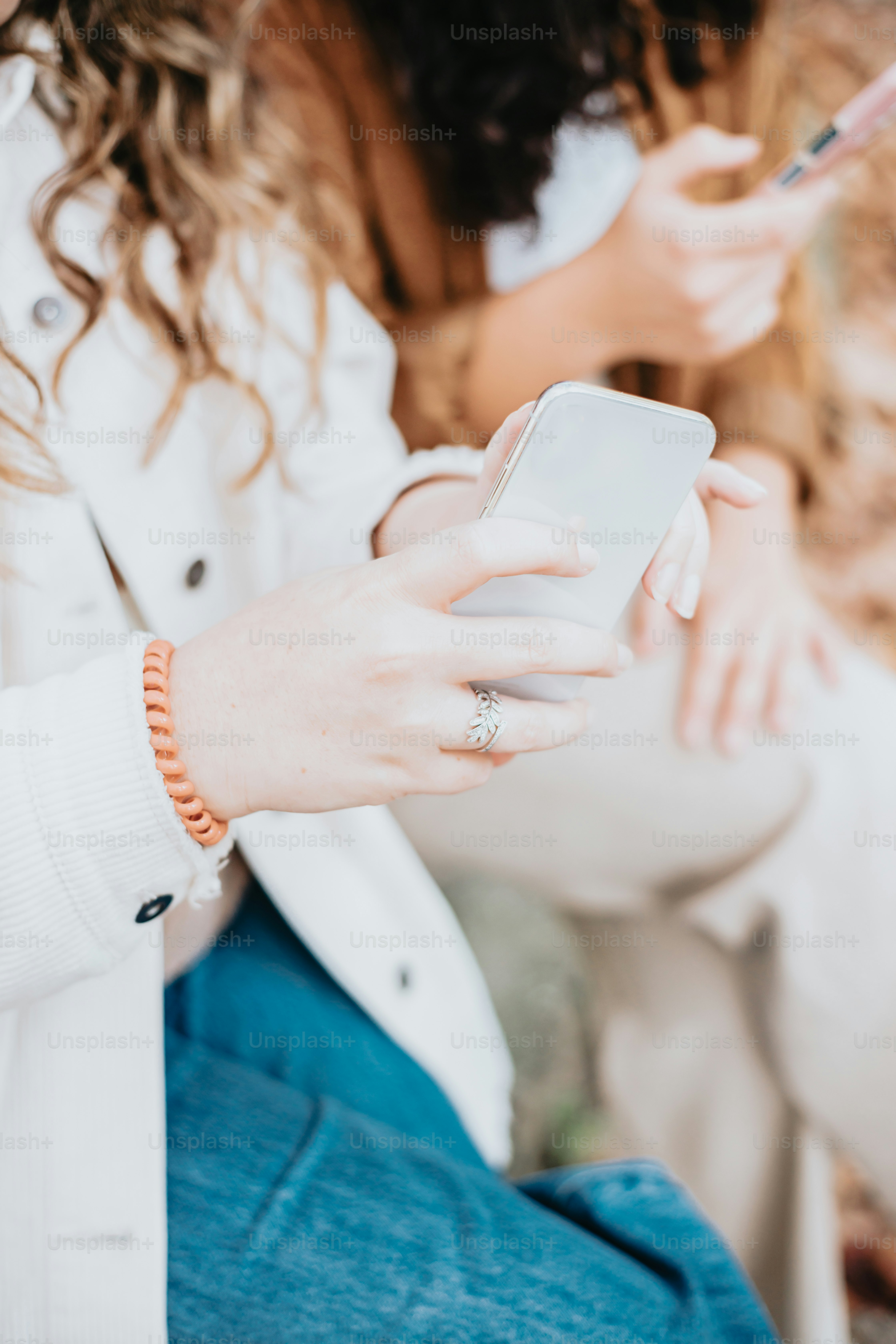 a woman in a white coat is holding a cell phone