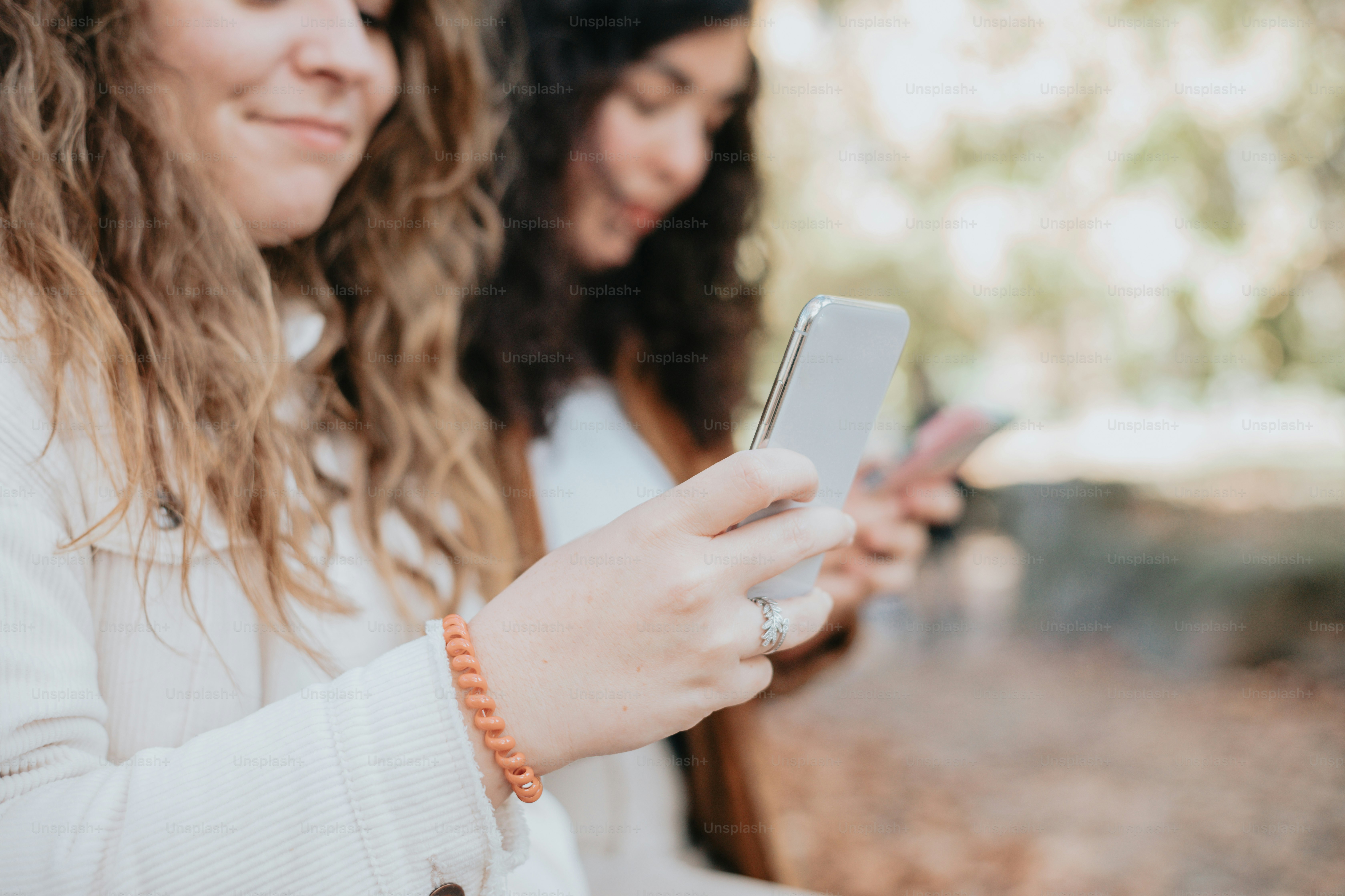 two women are looking at their cell phones