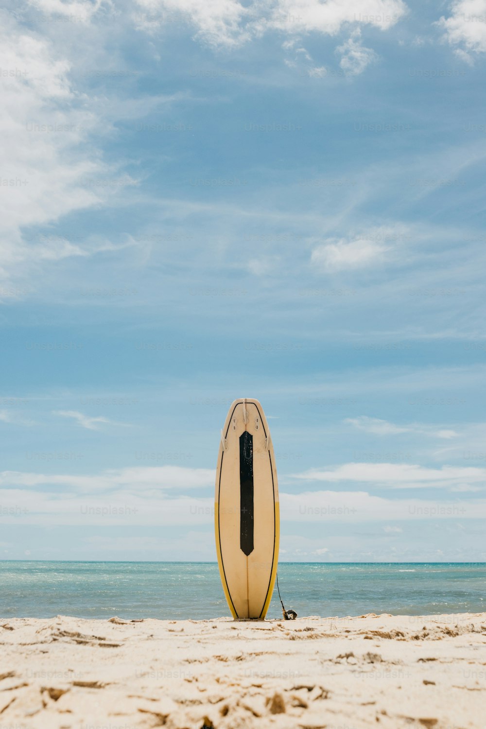 모래 사장 위에 앉아 있는 서핑보드